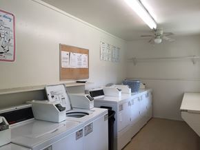 Beaumont apartment for rent - A laundromat with washers and dryers and a fan.