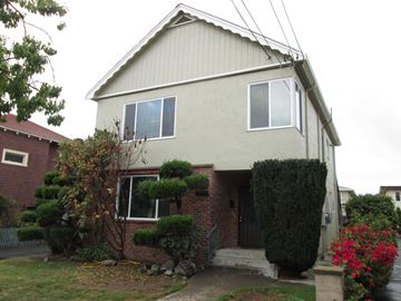 Alameda apartment for rent - A house with a grey roof and a red brick wall.
