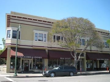 Alameda apartment for rent - A street view of a building with Gallagher & Lindsey real estate on the front.