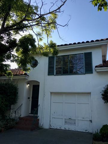 Oakland apartment for rent - A white house with a black door and a white garage door.