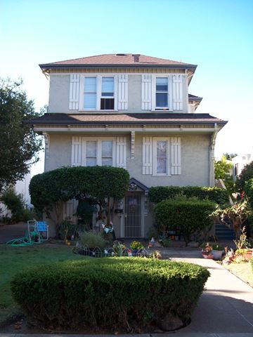 Alameda apartment for rent - A house with a grey facade and white shutters.