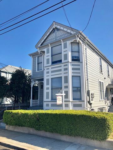 Alameda apartment for rent - A two-story house with a grey facade and white trim.