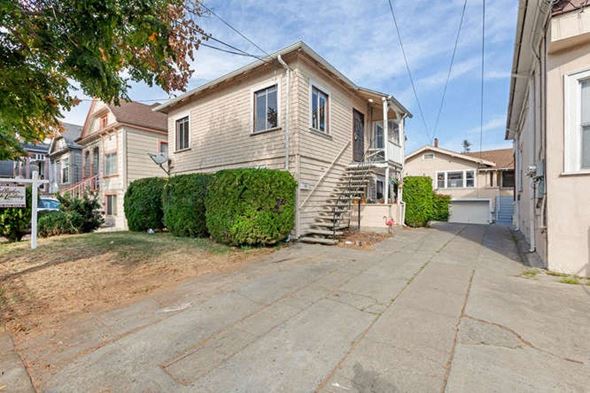 Alameda apartment for rent - A house with a driveway and a garage is surrounded by other houses.