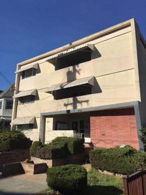 Oakland apartment for rent - A building with a red brick wall and a balcony.