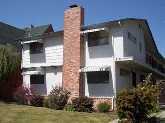 Alameda apartment for rent - A white two story house with a red brick chimney.