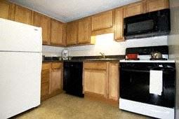 Foxboro apartment for rent - a kitchen with black and white appliances and wooden cabinets