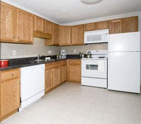 Keene apartment for rent - a kitchen with white appliances and wooden cabinets