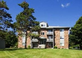 Keene apartment for rent - a large brick house with a green lawn and trees