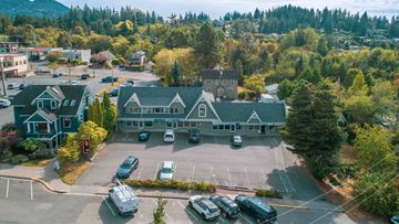 Bellingham apartment for rent - an aerial view of a large green house with cars in a parking lot
