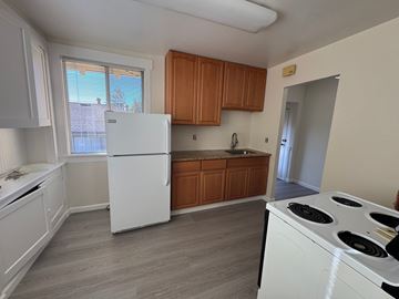 Alameda apartment for rent - A kitchen with white appliances and wooden cabinets.