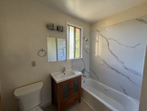 Alameda apartment for rent - A bathroom with a marble counter top and a white bathtub.