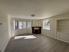 Alameda apartment for rent - A spacious living room with a fireplace and large windows.