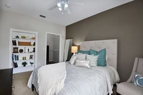 Jacksonville apartment for rent - A bedroom with a large bed and a ceiling fan.