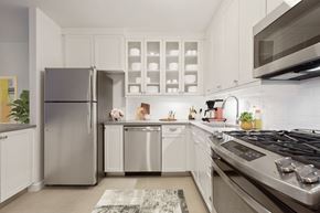 New York apartment for rent - a modern kitchen with stainless steel appliances and white cabinets