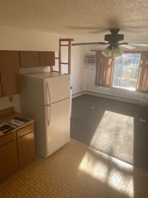 Hebron apartment for rent - an empty kitchen with a refrigerator and a ceiling fan