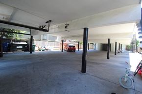 Alameda apartment for rent - A parking garage with a red car and a bicycle.