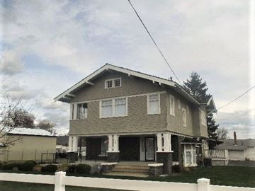 Yakima apartment for rent - A house with a white fence in front.