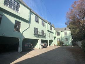 Alameda apartment for rent - a green building with cars parked in front of it