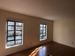 Alameda apartment for rent - an empty living room with two windows and wooden floors