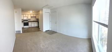 Bettendorf apartment for rent - A living room with a carpet and a door leading to a kitchen.