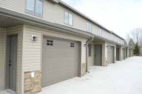 Mandan apartment for rent - a row of garage doors on the side of a building
