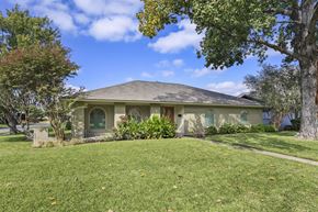 Richardson apartment for rent - A house with a green lawn and trees in front.