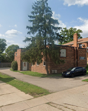 Cincinnati apartment for rent - A black car is parked in front of a brick building.
