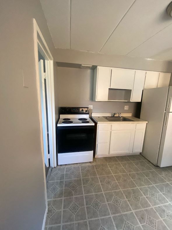 Cincinnati apartment for rent - A kitchen with white cabinets and a black oven.