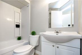 Toronto apartment for rent - A white bathroom with a toilet, sink, and bathtub.