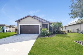 Parrish house for rent - a house with a driveway and a garage door