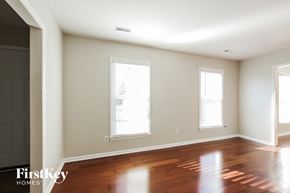 Charlotte house for rent - an empty living room with wood floors and two windows