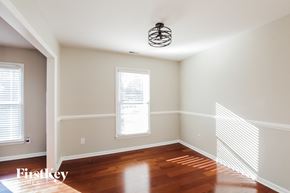 Charlotte house for rent - a living room with wood floors and a light fixture on the ceiling