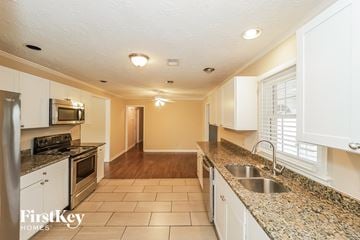 Austell house for rent - A kitchen with white cabinets and a granite counter top.