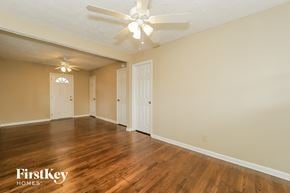 Austell house for rent - A spacious room with a ceiling fan and wooden flooring.