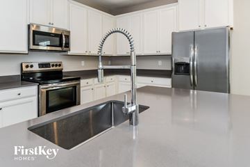 Jacksonville house for rent - a modern kitchen with stainless steel counter tops and white cabinets