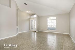 St Augustine house for rent - A spacious empty room with tiled flooring and a slanted ceiling.