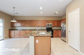 Surprise house for rent - a large kitchen with granite counter tops and wooden cabinets