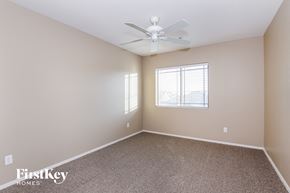 Surprise house for rent - a bedroom with a ceiling fan and a window