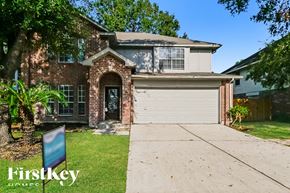 Humble house for rent - a brick house with a driveway and a white garage door