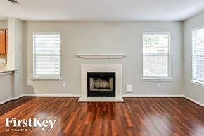 Humble house for rent - a living room with a fireplace and wooden floors