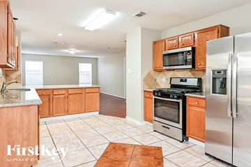 Humble house for rent - a kitchen with stainless steel appliances and wooden cabinets
