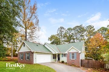 Conyers house for rent - a white and brick house with a green roof