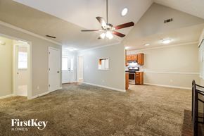 Conyers house for rent - a spacious living room with carpet and a ceiling fan