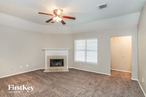 Humble house for rent - A living room with a fireplace and a ceiling fan.