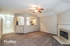 Humble house for rent - A spacious living room with a fireplace and a ceiling fan.