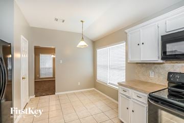 Humble house for rent - A kitchen with a stove top oven and a refrigerator.