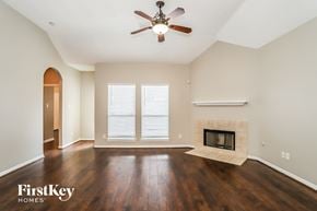 Magnolia house for rent - a living room with a fireplace and a ceiling fan