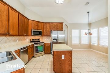 Magnolia house for rent - a kitchen with wooden cabinets and stainless steel appliances