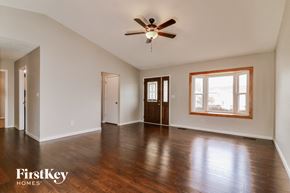 Arnold house for rent - A spacious room with wooden floors and a ceiling fan.