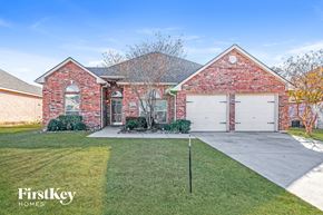 Midlothian house for rent - A brick house with a garage door and a sign that says FirstKey Homes.